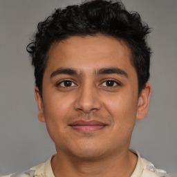 Joyful latino young-adult male with short  brown hair and brown eyes