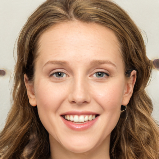 Joyful white young-adult female with long  brown hair and green eyes