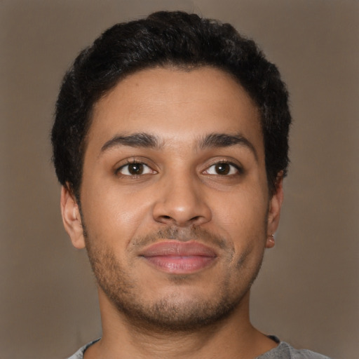 Joyful latino young-adult male with short  brown hair and brown eyes