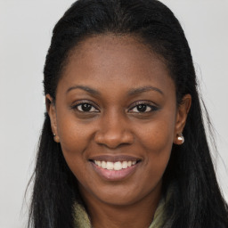 Joyful black young-adult female with long  brown hair and brown eyes