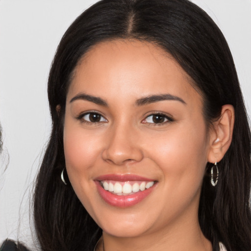 Joyful latino young-adult female with long  brown hair and brown eyes