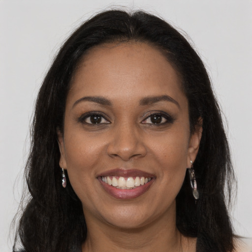 Joyful black young-adult female with long  brown hair and brown eyes