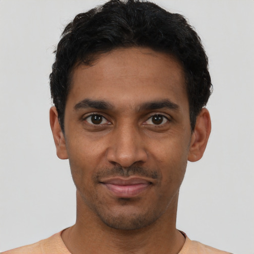 Joyful latino young-adult male with short  black hair and brown eyes