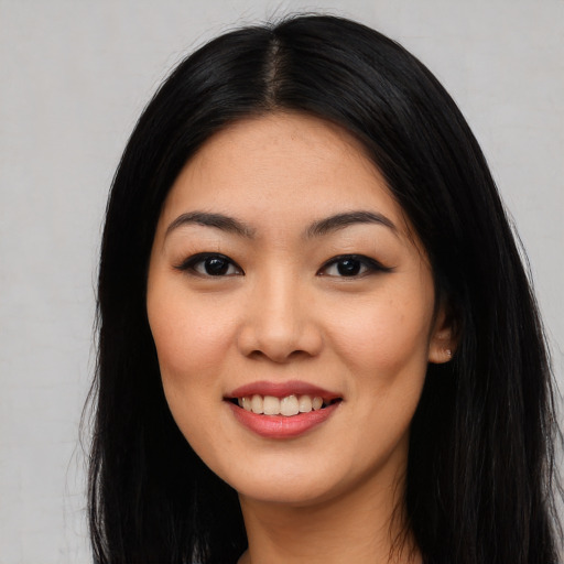 Joyful asian young-adult female with long  black hair and brown eyes