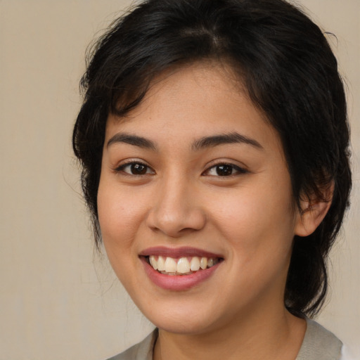 Joyful latino young-adult female with medium  brown hair and brown eyes