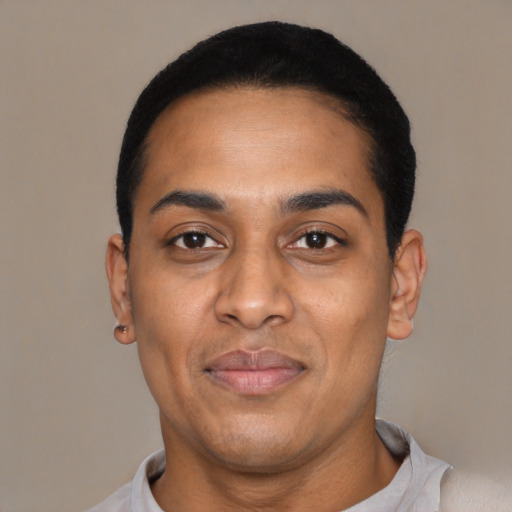 Joyful latino young-adult male with short  black hair and brown eyes