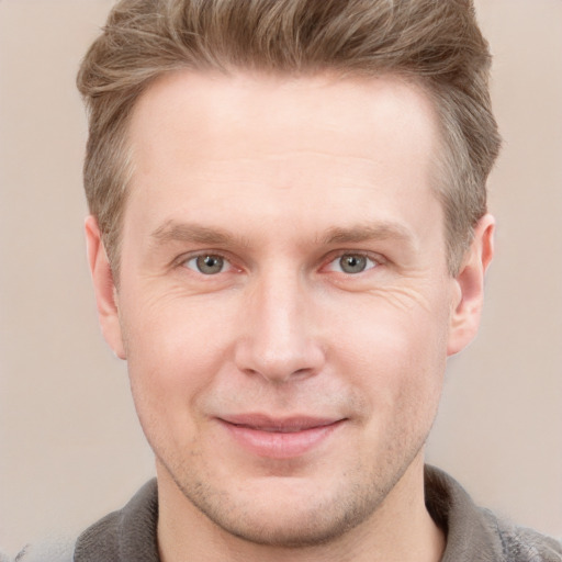 Joyful white young-adult male with short  brown hair and grey eyes