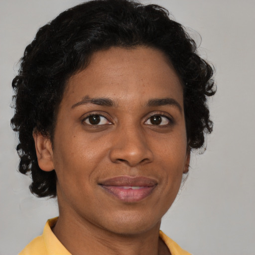 Joyful black adult female with short  brown hair and brown eyes
