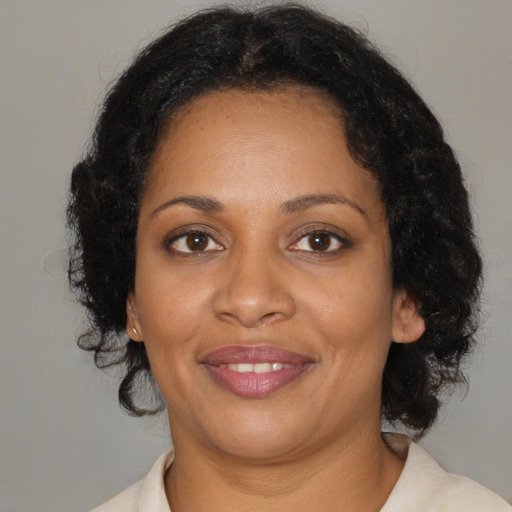 Joyful black adult female with medium  brown hair and brown eyes