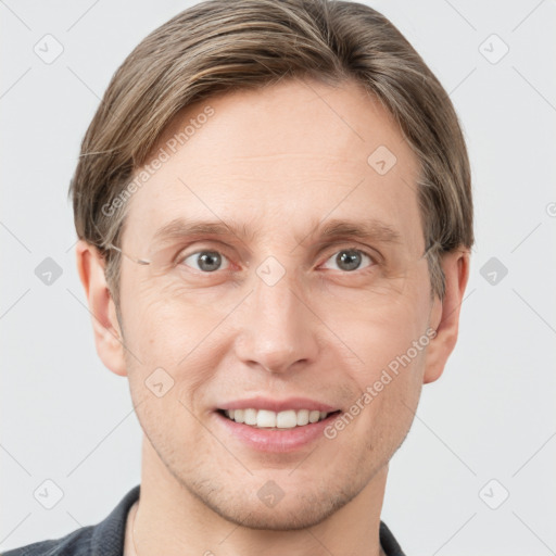 Joyful white adult male with short  brown hair and grey eyes