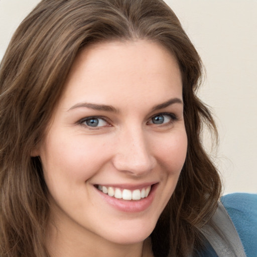 Joyful white young-adult female with long  brown hair and grey eyes