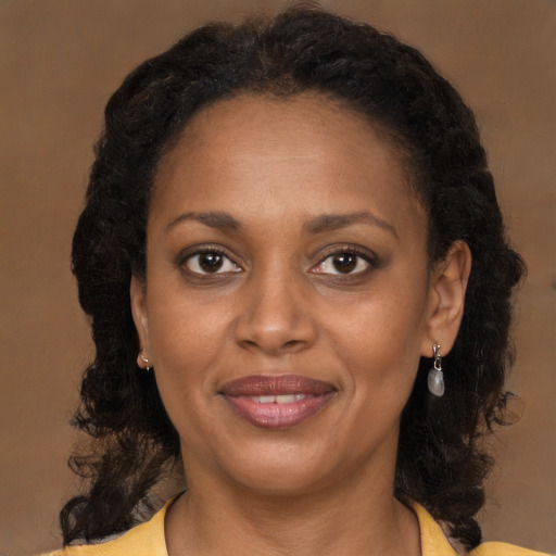 Joyful black adult female with medium  brown hair and brown eyes