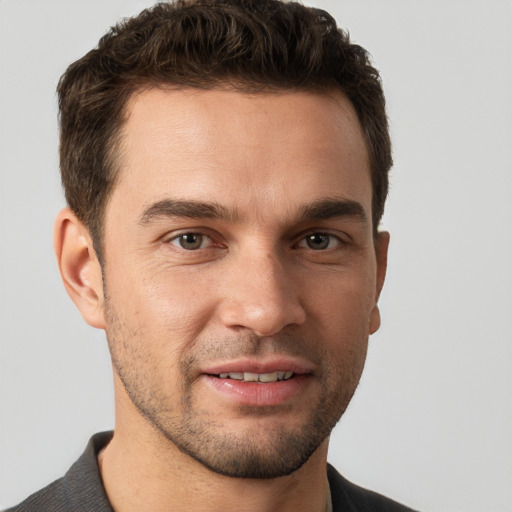 Joyful white young-adult male with short  brown hair and brown eyes