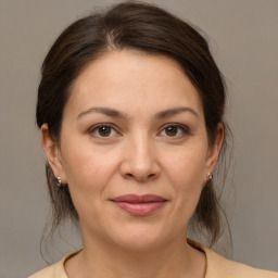 Joyful white adult female with medium  brown hair and brown eyes