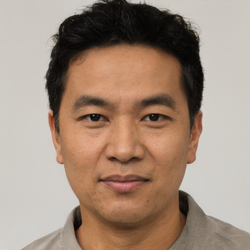 Joyful asian adult male with short  black hair and brown eyes