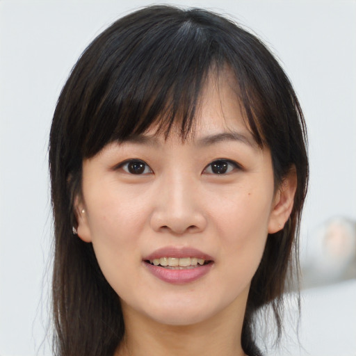 Joyful asian young-adult female with medium  brown hair and brown eyes