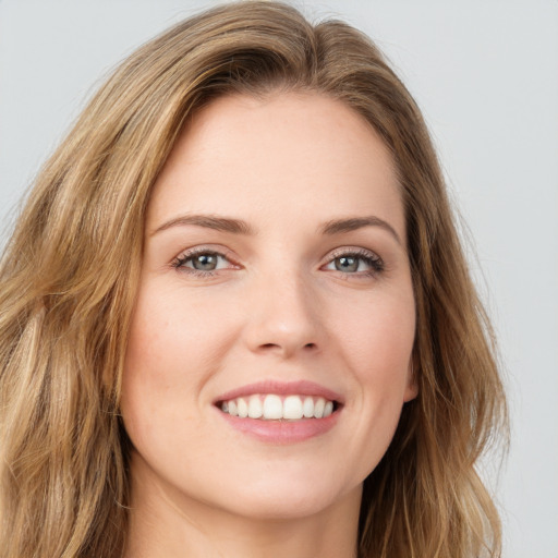 Joyful white young-adult female with long  brown hair and green eyes