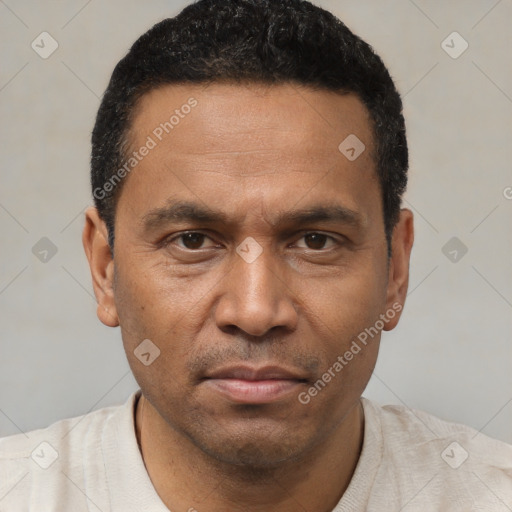 Joyful latino adult male with short  black hair and brown eyes