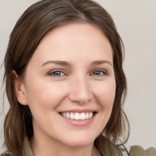 Joyful white young-adult female with medium  brown hair and grey eyes