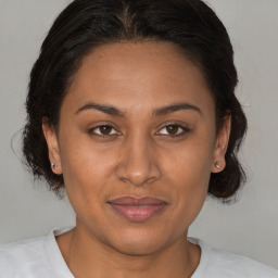 Joyful latino adult female with medium  brown hair and brown eyes