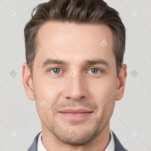 Joyful white young-adult male with short  brown hair and grey eyes