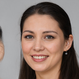 Joyful white young-adult female with long  brown hair and brown eyes