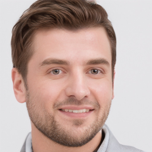 Joyful white young-adult male with short  brown hair and grey eyes