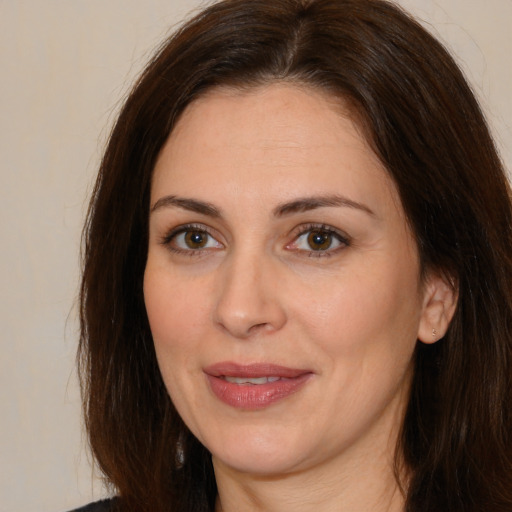 Joyful white adult female with long  brown hair and brown eyes