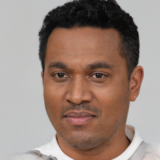 Joyful latino adult male with short  black hair and brown eyes