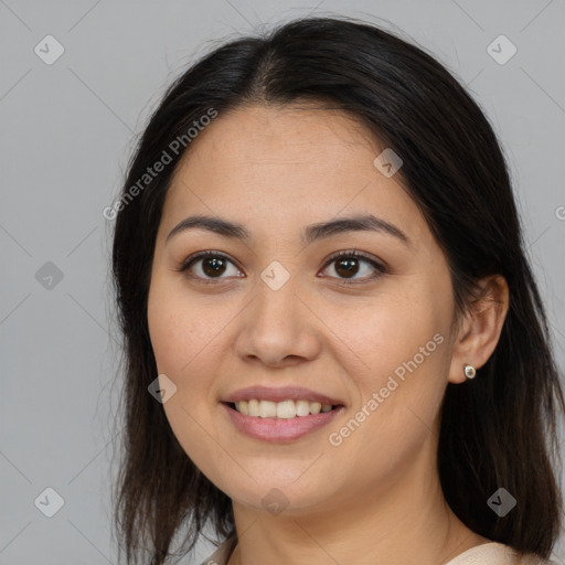 Joyful latino young-adult female with long  brown hair and brown eyes