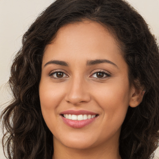 Joyful white young-adult female with long  brown hair and brown eyes