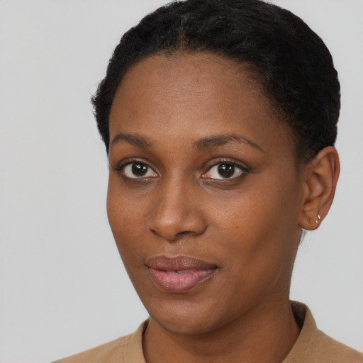Joyful black young-adult female with short  brown hair and brown eyes