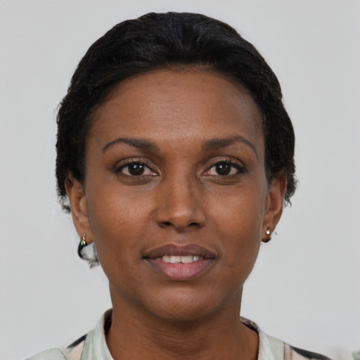 Joyful black adult female with short  black hair and brown eyes