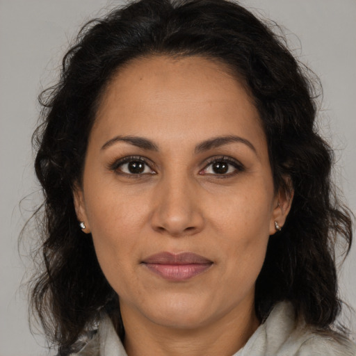 Joyful latino adult female with medium  brown hair and brown eyes
