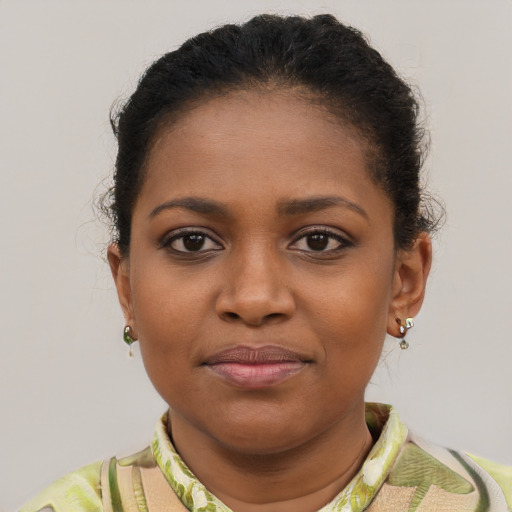 Joyful black young-adult female with short  brown hair and brown eyes