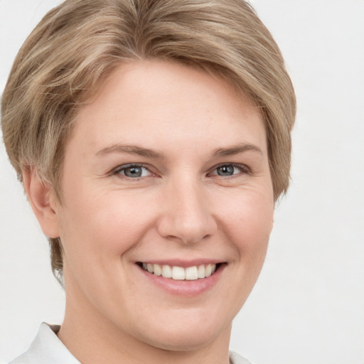 Joyful white young-adult female with short  brown hair and grey eyes