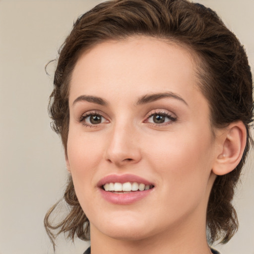 Joyful white young-adult female with medium  brown hair and green eyes