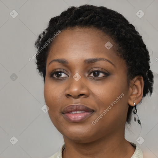 Joyful black young-adult female with short  black hair and brown eyes