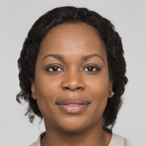 Joyful black young-adult female with long  brown hair and brown eyes