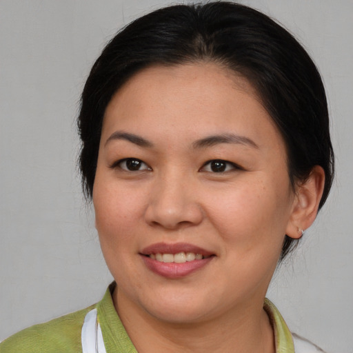 Joyful asian young-adult female with short  brown hair and brown eyes