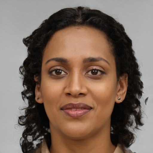 Joyful black young-adult female with medium  brown hair and brown eyes