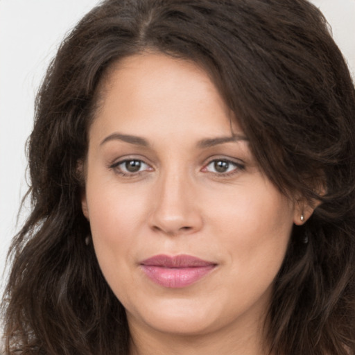 Joyful white young-adult female with long  brown hair and brown eyes