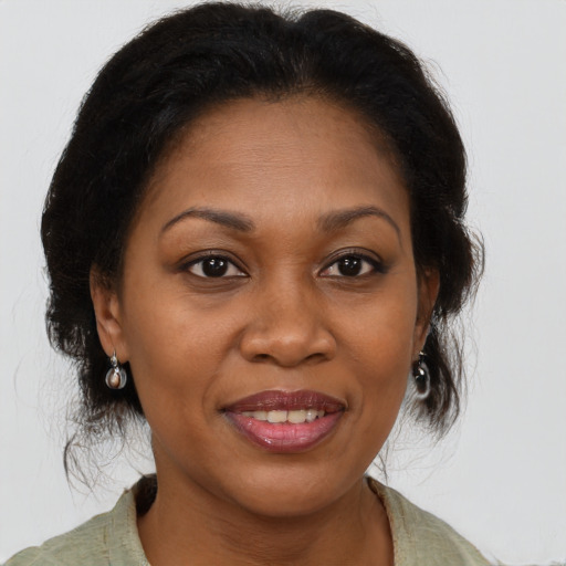 Joyful black adult female with medium  brown hair and brown eyes