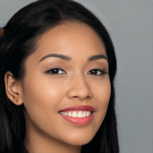 Joyful latino young-adult female with long  black hair and brown eyes