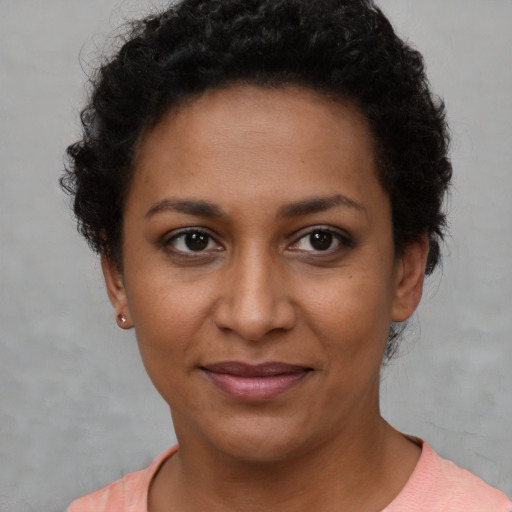 Joyful black young-adult female with short  brown hair and brown eyes