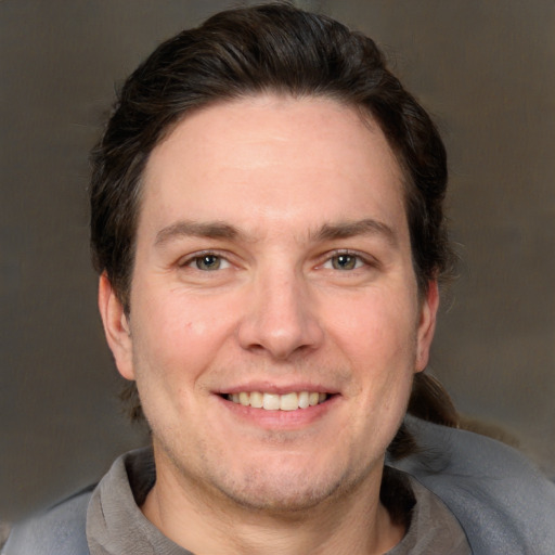 Joyful white adult male with short  brown hair and grey eyes