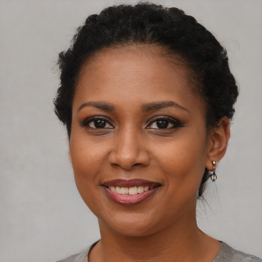 Joyful black young-adult female with short  brown hair and brown eyes