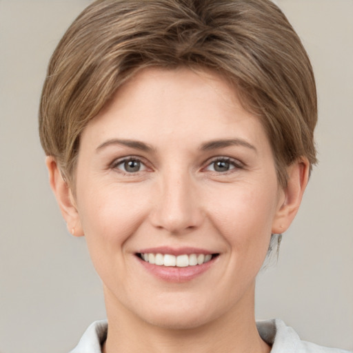 Joyful white young-adult female with short  brown hair and grey eyes