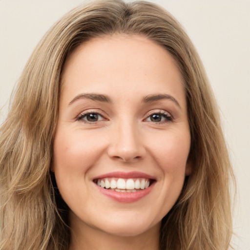 Joyful white young-adult female with long  brown hair and brown eyes