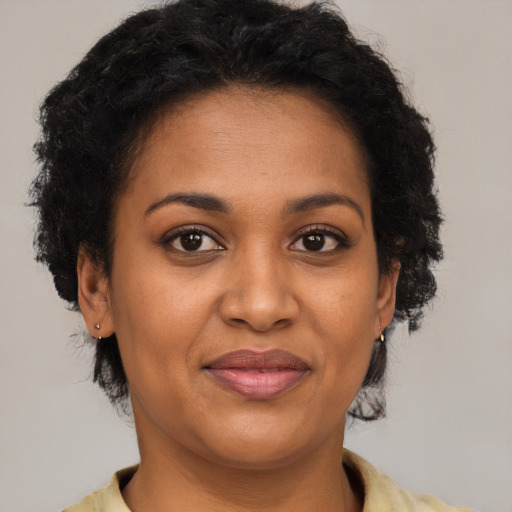 Joyful black young-adult female with short  brown hair and brown eyes